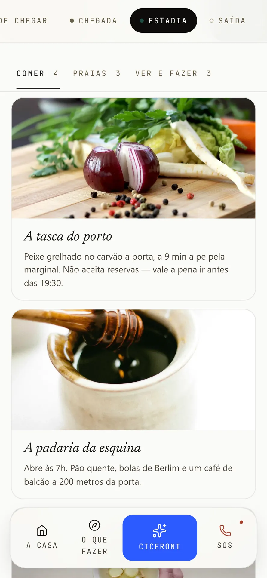 O guia no telemóvel, aberto nas recomendações do anfitrião: separadores de comer, praias e o que ver, com o sítio do peixe grelhado e a padaria que abre às sete.